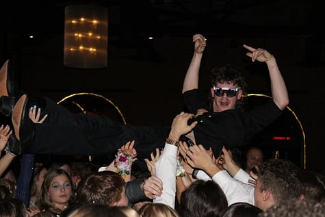 Senior Jake Miller crowd surfs as classmates hold him up on the dance floor at Windows on the River. 