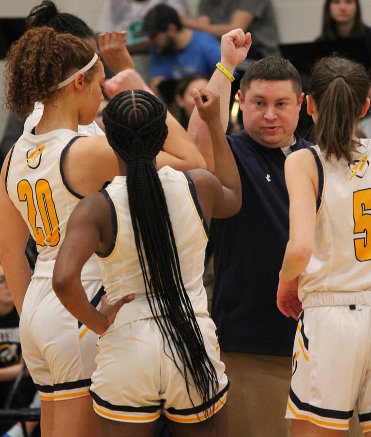 Head Coach Carl Singer prepares his team after a timeout. Grouped around him are freshmen Carlee Bedford and Olivia Johnson-Wilson and sophomore Sydney Abbhul. 