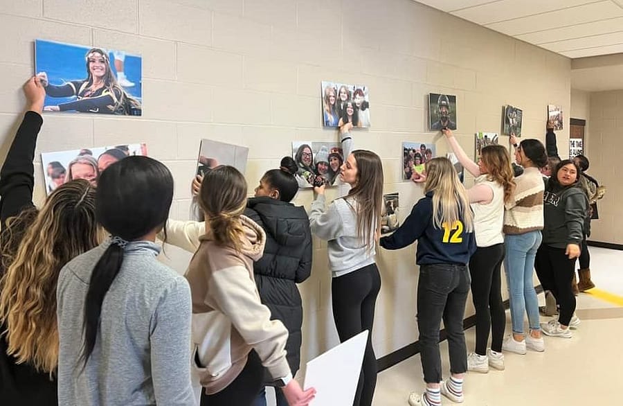 Yearbook staff members contemplate the arrangement of the photos for the most impact on the school walls.