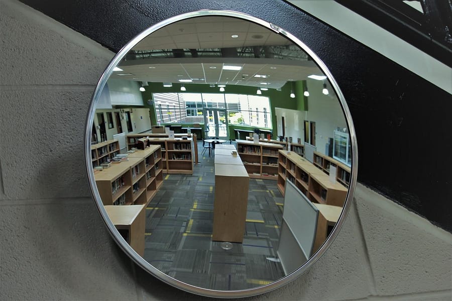 Looking into the mirror you are able to see the wonderful library provided to the students and staff.  The library is always open for you to check out books