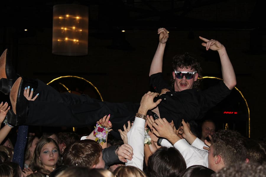 Senior+Jake+Miller+crowd+surfs+as+classmates+hold+him+up+on+the+dance+floor+at+Windows+on+the+River.+