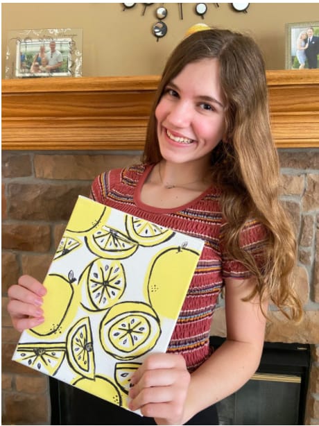 Freshman Jessica Reece shows off her lemon painting.